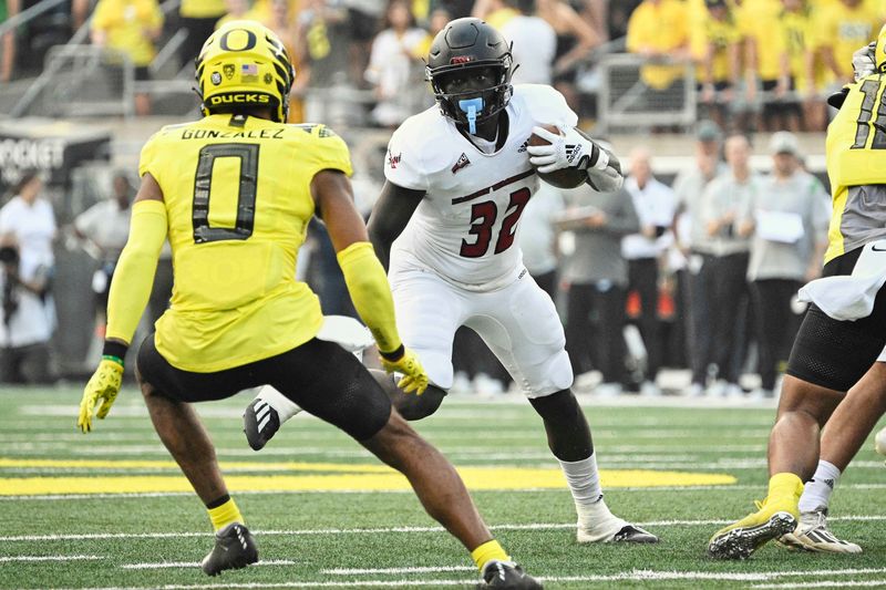 Sep 10, 2022; Eugene, Oregon, USA;  Eastern Washington Eagles running back Tuna Altahir (32) runs with the ball during the first half against Oregon Ducks defensive back Christian Gonzalez (0) at Autzen Stadium. Mandatory Credit: Troy Wayrynen-USA TODAY Sports