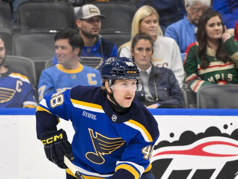 Nov 19, 2024; St. Louis, Missouri, USA;  St. Louis Blues defenseman Scott Perunovich (48) controls the puck against the Minnesota Wild during the first period at Enterprise Center. Mandatory Credit: Jeff Curry-Imagn Images