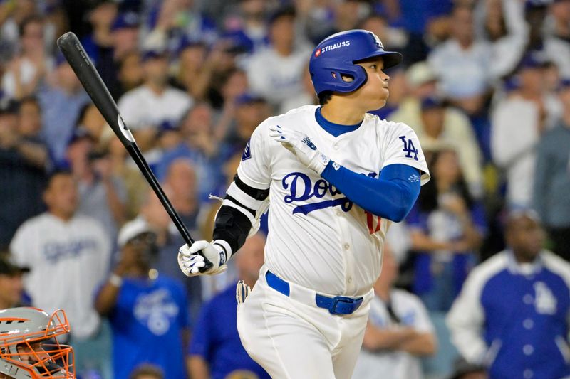 Oct 20, 2024; Los Angeles, California, USA; Los Angeles Dodgers designated hitter Shohei Ohtani (17) hits an RBI single in the sixth inning against the New York Mets during game six of the NLCS for the 2024 MLB playoffs at Dodger Stadium. Mandatory Credit: Jayne Kamin-Oncea-Imagn Images