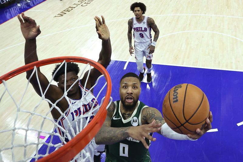 PHILADELPHIA, PENNSYLVANIA - FEBRUARY 25: Damian Lillard #0 of the Milwaukee Bucks shoots a lay up past Mo Bamba #5 of the Philadelphia 76ers during the third quarter at the Wells Fargo Center on February 25, 2024 in Philadelphia, Pennsylvania. (Photo by Tim Nwachukwu/Getty Images)