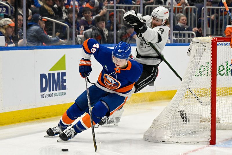 Mar 13, 2026; Elmont, New York, USA; New York Islanders defenseman Matthew Schaefer (48) skates the puck from behind the net chased by Los Angeles Kings right wing Adrian Kempe (9) during the third period at UBS Arena. Mandatory Credit: Dennis Schneidler-Imagn Images