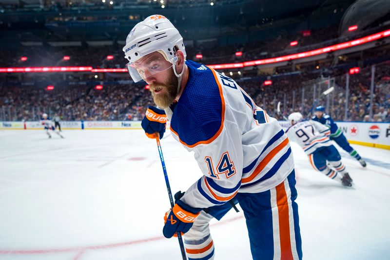 May 8, 2024; Vancouver, British Columbia, CAN; Edmonton Oilers defenseman Mattias Ekholm (14) looks for the loose puck against the Vancouver Canucks during the third period in game one of the second round of the 2024 Stanley Cup Playoffs at Rogers Arena. Mandatory Credit: Bob Frid-USA TODAY Sports