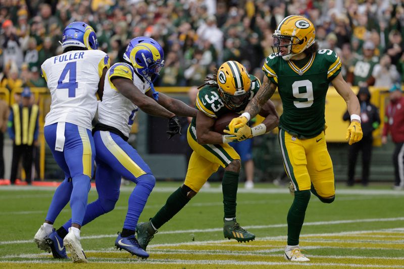 Green Bay Packers running back Aaron Jones (33) scores a 3-yard rushing touchdown during the first half of an NFL football game against the Los Angeles Rams, Sunday, Nov. 5, 2023, in Green Bay, Wis. (AP Photo/Matt Ludtke)