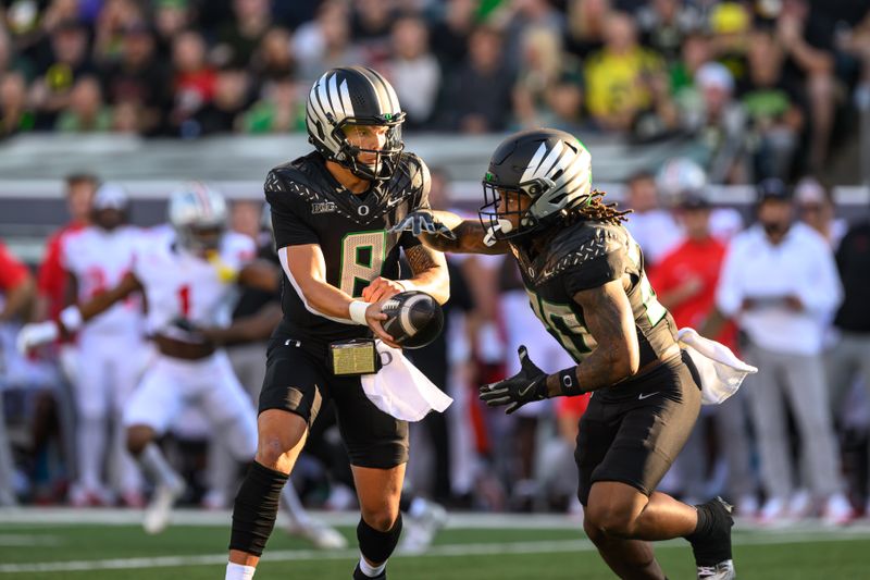 Oct 12, 2024; Eugene, Oregon, USA; Oregon Ducks quarterback Dillon Gabriel (8) hands the ball to running back Jordan James (20) during the first quarter against the Ohio State Buckeyes at Autzen Stadium. Mandatory Credit: Craig Strobeck-Imagn Images