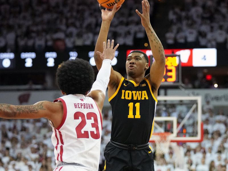 Feb 22, 2023; Madison, Wisconsin, USA; Iowa Hawkeyes guard Tony Perkins (11) shoots the ball under coverage by Wisconsin Badgers guard Chucky Hepburn (23) during the first half at the Kohl Center. Mandatory Credit: Kayla Wolf-USA TODAY Sports