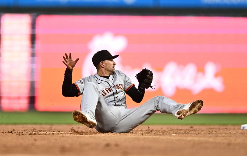 May 5, 2024; Philadelphia, Pennsylvania, USA; San Francisco Giants shortstop Nick Ahmed (16) falls to commit a throwing error and allow a runner against the Philadelphia Phillies in the second inning at Citizens Bank Park. Mandatory Credit: Kyle Ross-USA TODAY Sports