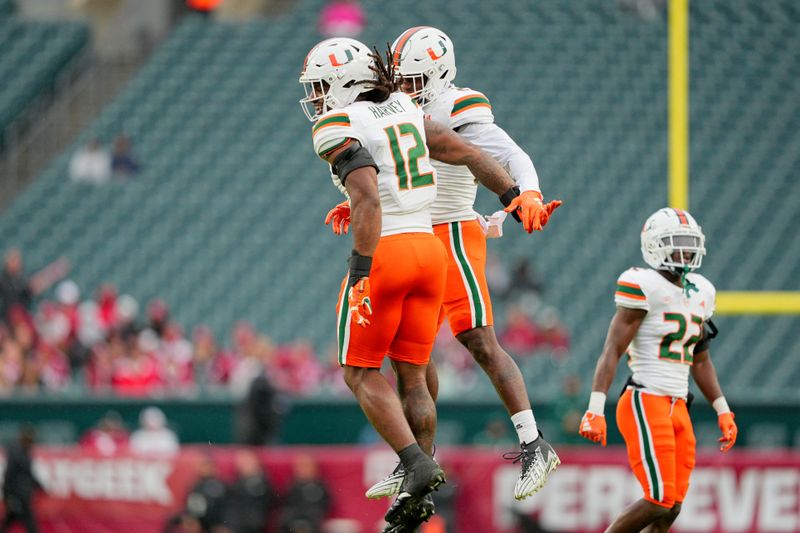 Sep 23, 2023; Philadelphia, Pennsylvania, USA;  Miami Hurricanes defensive lineman Jahfari Harvey (12) celebrates his fumble recovery with linebacker K.J. Cloyd (23) in the second half against the Temple Owls at Lincoln Financial Field. Mandatory Credit: Andy Lewis-USA TODAY Sports