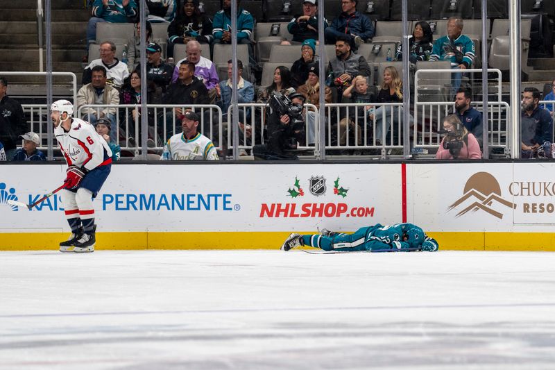 Nov 27, 2023; San Jose, California, USA; San Jose Sharks right wing Kevin Labanc (62) lays injured on the ice from a high stick hit by Washington Capitals defenseman Joel Edmundson (6) during the third period at SAP Center at San Jose. Mandatory Credit: Neville E. Guard-USA TODAY Sports