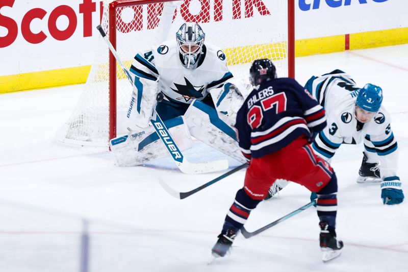 Oct 18, 2024; Winnipeg, Manitoba, CAN;  San Jose Sharks goalie Vitek Vanecek (41) makes a save on a shot by Winnipeg Jets forward Nikolaj Ehlers (27) during the third period at Canada Life Centre. Mandatory Credit: Terrence Lee-Imagn Images