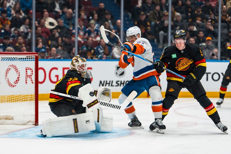 Jan 19, 2026; Vancouver, British Columbia, CAN; New York Islanders forward Anders Lee (27) vies for the puck against Vancouver Canucks defenseman Tom Willander (5) and goaltender Kevin Lankinen (32) in the first period at Rogers Arena. Mandatory Credit: Bob Frid-Imagn Images