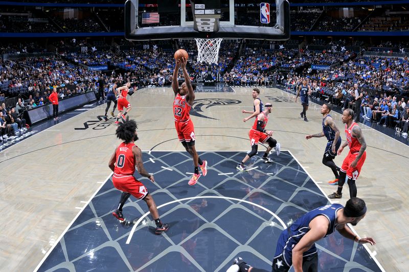 ORLANDO, FL - FEBRUARY 10:Ayo Dosunmu #12 of the Chicago Bulls grabs a rebound during the game against the Orlando Magic  on February 10, 2024 at the Kia Center in Orlando, Florida. NOTE TO USER: User expressly acknowledges and agrees that, by downloading and or using this photograph, User is consenting to the terms and conditions of the Getty Images License Agreement. Mandatory Copyright Notice: Copyright 2024 NBAE (Photo by Fernando Medina/NBAE via Getty Images)