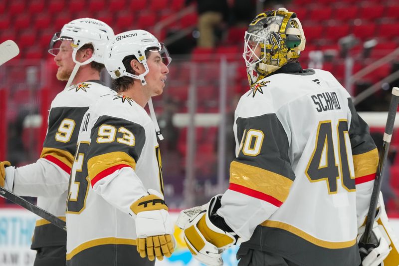 Oct 28, 2025; Raleigh, North Carolina, USA; Vegas Golden Knights goaltender Akira Schmid (40) and right wing Mitch Marner (93) celebrate their victory after the game against the Carolina Hurricanes at Lenovo Center. Mandatory Credit: James Guillory-Imagn Images