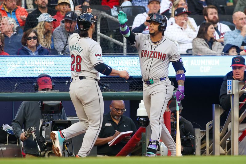 Apr 6, 2024; Atlanta, Georgia, USA; Arizona Diamondbacks third baseman Eugenio Suarez (28) celebrates after scoring with second baseman Ketel Marte (4) against the Atlanta Braves in the first inning at Truist Park. Mandatory Credit: Brett Davis-USA TODAY Sports