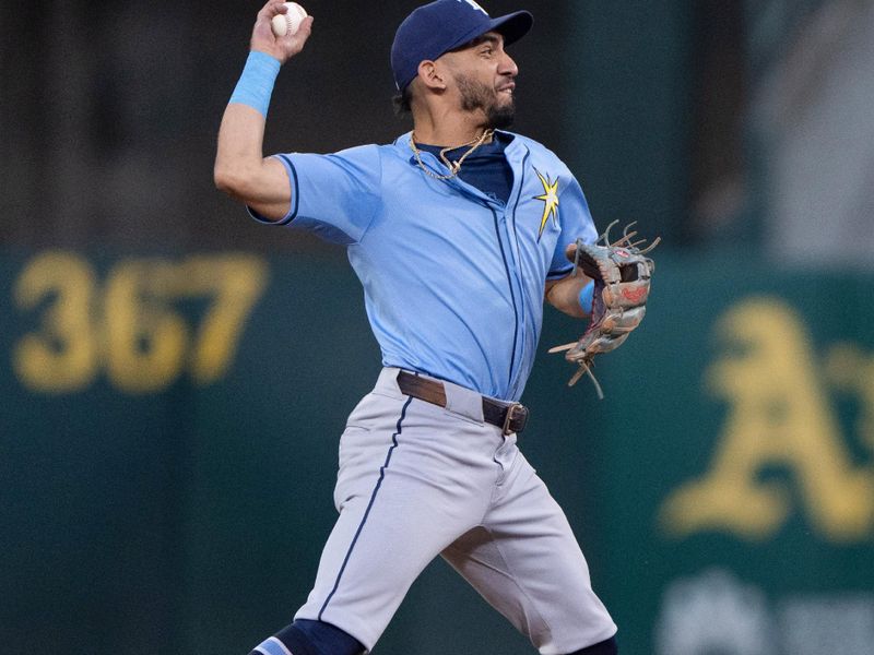 Aug 19, 2024; Oakland, California, USA; Tampa Bay Rays shortstop José Caballero (7) throws the ball to first base during the fourth inning against the Oakland Athletics at Oakland-Alameda County Coliseum. Mandatory Credit: Stan Szeto-USA TODAY Sports