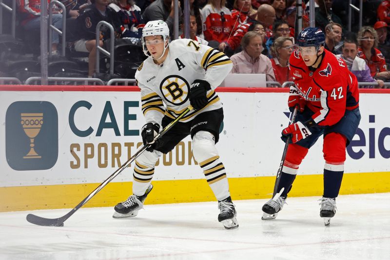 Apr 15, 2024; Washington, District of Columbia, USA; Boston Bruins defenseman Charlie McAvoy (73) skates with the puck as Washington Capitals defenseman Martin Fehervary (42) defends in the second period at Capital One Arena. Mandatory Credit: Geoff Burke-USA TODAY Sports