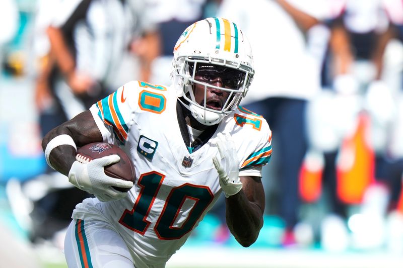 Miami Dolphins wide receiver Tyreek Hill runs for yardage during the first half of an NFL football game against the New England Patriots, Sunday, Oct. 29, 2023, in Miami Gardens, Fla. (AP Photo/Wilfredo Lee)