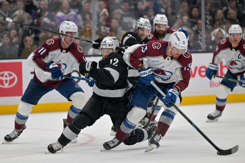 Oct 7, 2025; Los Angeles, California, USA;  Los Angeles Kings left wing Trevor Moore (12) and Colorado Avalanche right wing Valeri Nichushkin (13) battle for the puck during the second period at Crypto.com Arena. Mandatory Credit: Jayne Kamin-Oncea-Imagn Images