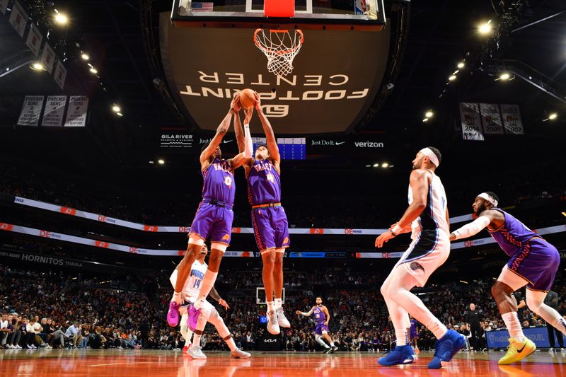 PHOENIX, AZ - NOVEMBER 18: Ryan Dunn #0 and Oso Ighodaro #4 of the Phoenix Suns go up for the rebound during the game against the Orlando Magic on November 18, 2024 at Footprint Center in Phoenix, Arizona. NOTE TO USER: User expressly acknowledges and agrees that, by downloading and or using this photograph, user is consenting to the terms and conditions of the Getty Images License Agreement. Mandatory Copyright Notice: Copyright 2024 NBAE (Photo by Barry Gossage/NBAE via Getty Images)