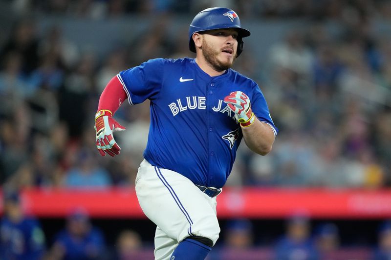 Apr 14, 2024; Toronto, Ontario, CAN; Toronto Blue Jays catcher Alejandro Kirk (30) heads for first base on his single against the Colorado Rockies during the sixth inning at Rogers Centre. Mandatory Credit: John E. Sokolowski-USA TODAY Sports