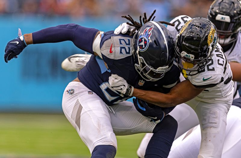 Tennessee Titans running back Derrick Henry (22) is tackled by Jacksonville Jaguars cornerback Tyson Campbell (32) during their NFL football game Sunday, Jan. 7, 2024, in Nashville, Tenn. (AP Photo/Wade Payne)