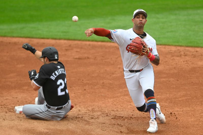 Jul 4, 2024; Cleveland, Ohio, USA; Cleveland Guardians shortstop Brayan Rocchio (4) throws to first base beside Chicago White Sox left fielder Andrew Benintendi (23) in the third inning at Progressive Field. Mandatory Credit: David Richard-USA TODAY Sports