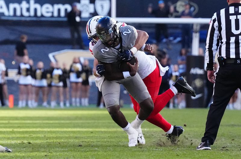 Nov 11, 2023; Boulder, Colorado, USA; Arizona Wildcats linebacker Dominic Lolesio (42) tackles Colorado Buffaloes quarterback Shedeur Sanders (2) in the second half at Folsom Field. Mandatory Credit: Ron Chenoy-USA TODAY Sports