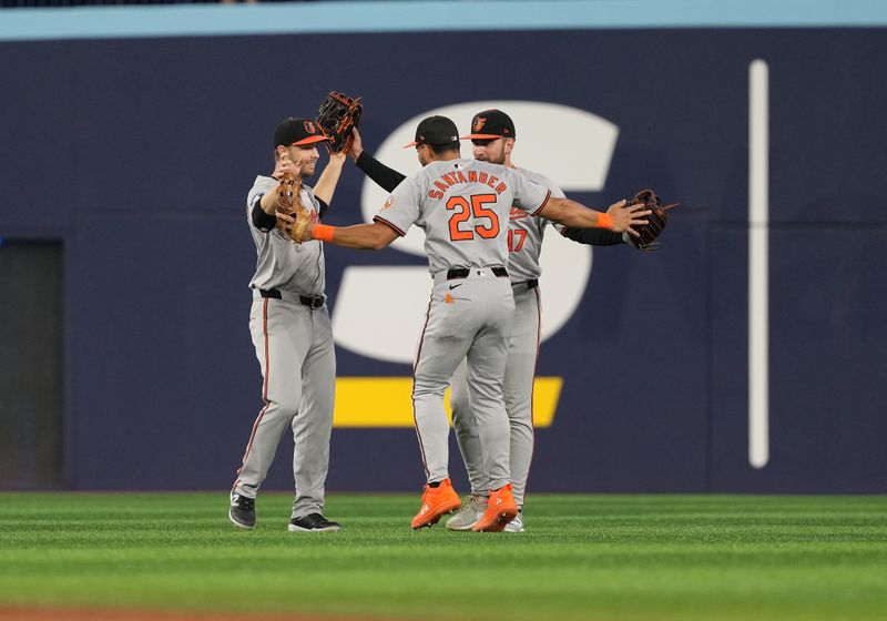 Aug 7, 2024; Toronto, Ontario, CAN; Baltimore Orioles left ielder Austin Slater (15) and center fielder Colton Cowser (17) and right fielder Anthony Santander (25) celebrate the win against the Toronto Blue Jays at the end of he ninth inning at Rogers Centre. Mandatory Credit: Nick Turchiaro-USA TODAY Sports