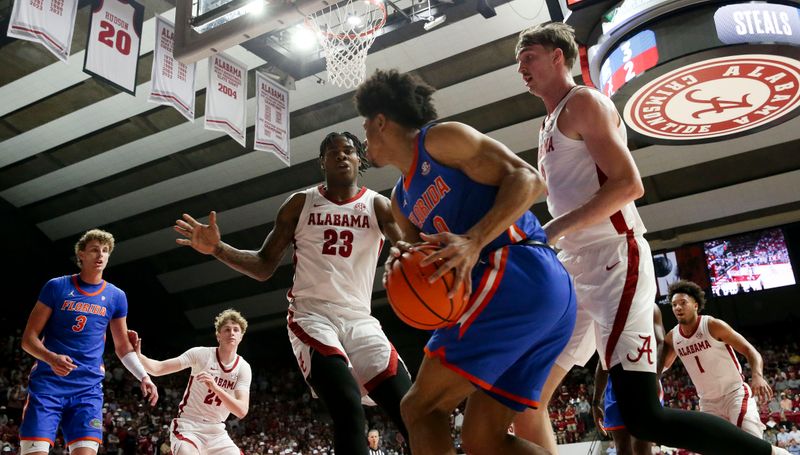 Feb 21, 2024; Tuscaloosa, Alabama, USA; Alabama Crimson Tide forward Grant Nelson (2) and forward Nick Pringle (23) stop a baseline drive by Florida Gators forward Zyon Pullin (0) at Coleman Coliseum. Mandatory Credit: Gary Cosby Jr.-USA TODAY Sports