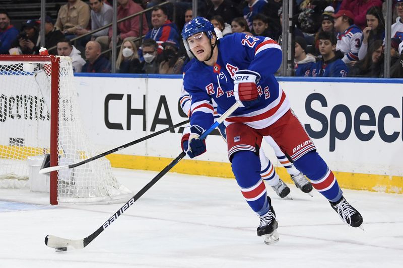 Dec 22, 2023; New York, New York, USA;  New York Rangers defenseman Adam Fox (23) clears the puck against the Edmonton Oilers during the first period at Madison Square Garden. Mandatory Credit: Dennis Schneidler-USA TODAY Sports