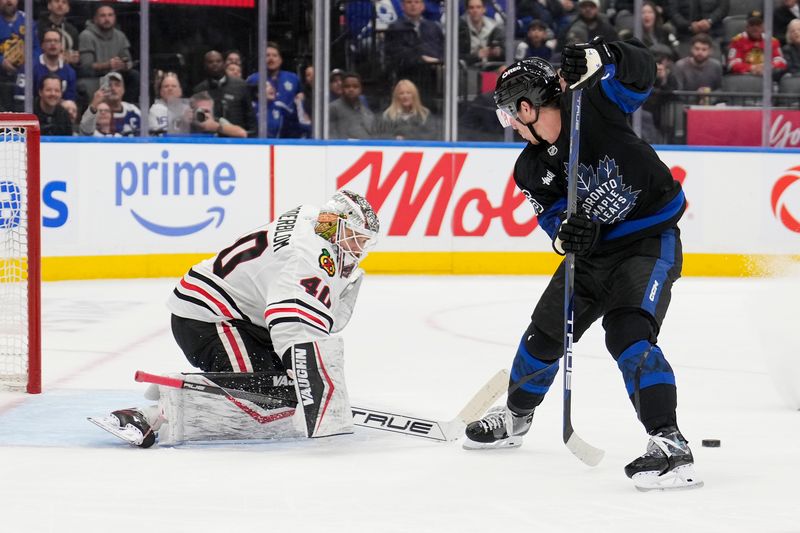 Dec 2, 2024; Toronto, Ontario, CAN; Toronto Maple Leafs forward Mitch Marner (16) passes the puck back on a breakaway against Chicago Blackhawks goaltender Arvid Soderblom (40) during the third period at Scotiabank Arena. Mandatory Credit: John E. Sokolowski-Imagn Images