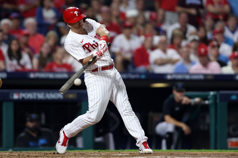 Oct 4, 2023; Philadelphia, Pennsylvania, USA; Philadelphia Phillies catcher J.T. Realmuto (10) hits a double against the Miami Marlins during the second inning for game two of the Wildcard series for the 2023 MLB playoffs at Citizens Bank Park. Mandatory Credit: Bill Streicher-USA TODAY Sports