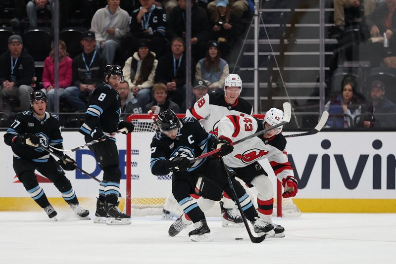 Dec 19, 2025; Salt Lake City, Utah, USA; Utah Mammoth right wing Clayton Keller (9) and New Jersey Devils defenseman Luke Hughes (43) battle for the puck during the first period at Delta Center. Mandatory Credit: Rob Gray-Imagn Images