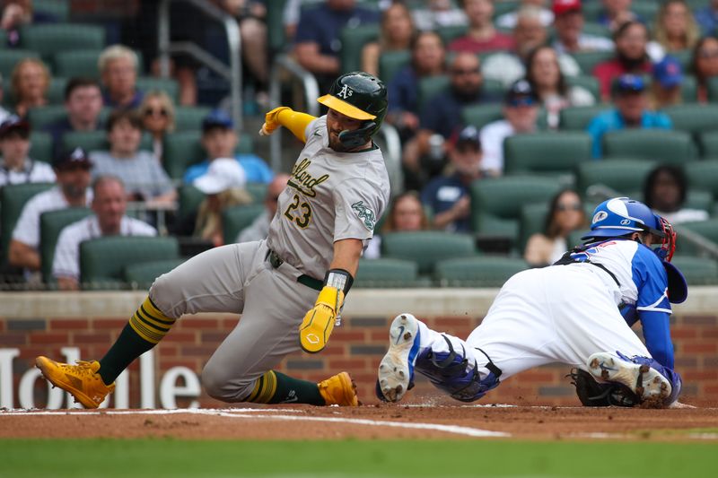 Jun 1, 2024; Atlanta, Georgia, USA; Oakland Athletics catcher Shea Langeliers (23) scores past Atlanta Braves catcher Travis d'Arnaud (16) in the first inning at Truist Park. Mandatory Credit: Brett Davis-USA TODAY Sports