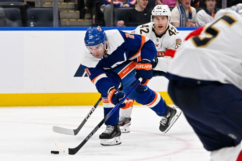 Jan 27, 2024; Elmont, New York, USA; New York Islanders center Kyle Palmieri (21) skates with the puck defended by Florida Panthers defenseman Gustav Forsling (42) during the second period at UBS Arena. Mandatory Credit: Dennis Schneidler-USA TODAY Sports