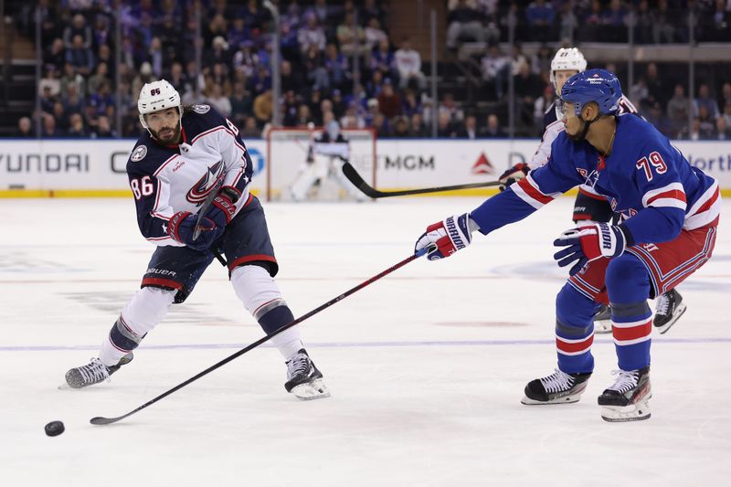 Feb 28, 2024; New York, New York, USA; Columbus Blue Jackets right wing Kirill Marchenko (86) plays the puck forward against New York Rangers defenseman K'Andre Miller (79) during the third period at Madison Square Garden. Mandatory Credit: Brad Penner-USA TODAY Sports