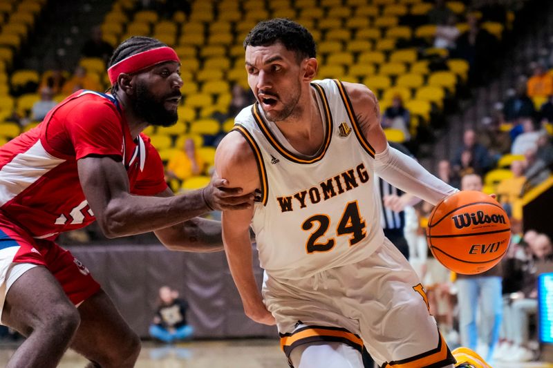 Jan 31, 2023; Laramie, Wyoming, USA; Wyoming Cowboys guard Hunter Maldonado (24) drives against Fresno State Bulldogs guard Jordan Campbell (5) during the first half at Arena-Auditorium. Mandatory Credit: Troy Babbitt-USA TODAY Sports