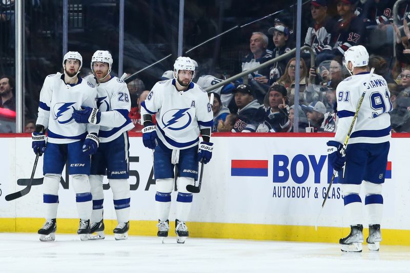 Jan 6, 2023; Winnipeg, Manitoba, CAN;  Tampa Bay Lightning forward Nikita Kucherov (86) is congratulated by his team mates on his goal against the Winnipeg Jets during the second period at Canada Life Centre. Mandatory Credit: Terrence Lee-USA TODAY Sports