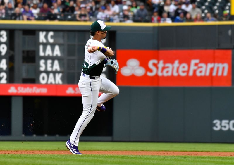 May 11, 2024; Denver, Colorado, USA; Colorado Rockies shortstop Ezequiel Tovar (14) makes a throw to retire a runner at first base against the Texas Rangers during the third inning at Coors Field. Mandatory Credit: John Leyba-USA TODAY Sports