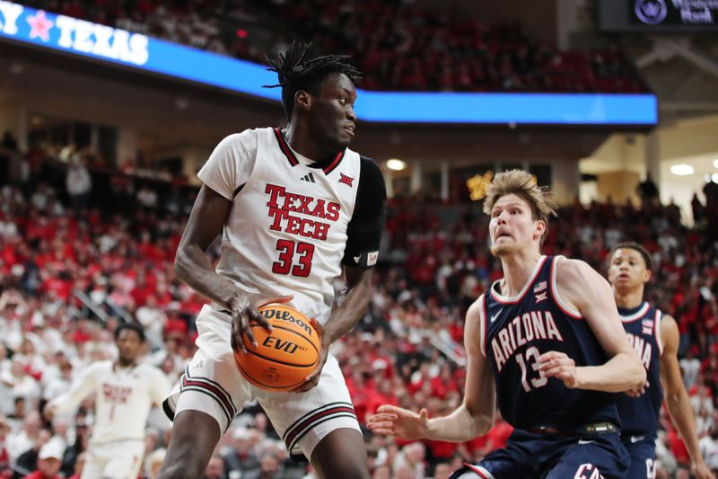 Jan 18, 2025; Lubbock, Texas, USA;  Texas Tech Red Raiders forward Federiko Federiko (33) pulls down a rebound against Arizona Wildcats Henri Veesaar (13) in the second half at United Supermarkets Arena. Mandatory Credit: Michael C. Johnson-Imagn Images