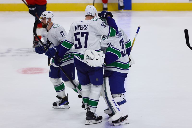 Oct 17, 2024; Sunrise, Florida, USA; Vancouver Canucks defenseman Tyler Myers (57) celebrates with goaltender Kevin Lankinen (32) after the game against the Florida Panthers at Amerant Bank Arena. Mandatory Credit: Sam Navarro-Imagn Images