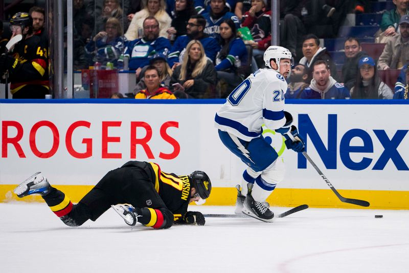 Dec 12, 2023; Vancouver, British Columbia, CAN; Tampa Bay Lightning forward Nicholas Paul (20) drives past Vancouver Canucks forward Elias Pettersson (40) in the first period at Rogers Arena. Mandatory Credit: Bob Frid-USA TODAY Sports