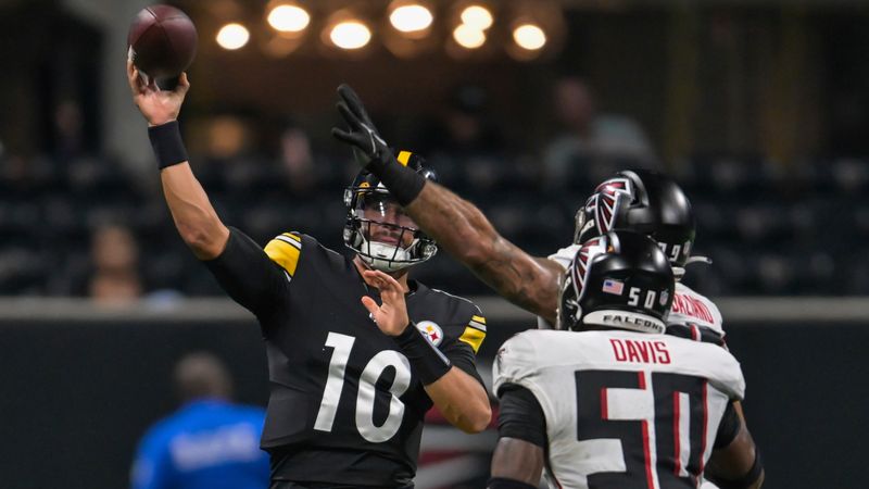 Pittsburgh Steelers quarterback Mitch Trubisky makes a pass before getting hit by Atlanta Falcons defensive end Joe Gaziano and linebacker Tae Davis during the first half of a preseason NFL football game Thursday, Aug. 24, 2023, in Atlanta. (AP Photo/Hakim Wright)