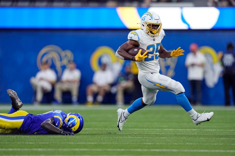 Los Angeles Chargers running back Joshua Kelley, right, jumps past Los Angeles Rams cornerback Robert Rochell during the first half of a preseason NFL football game Saturday, Aug. 12, 2023, in Inglewood, Calif. (AP Photo/Mark J. Terrill)