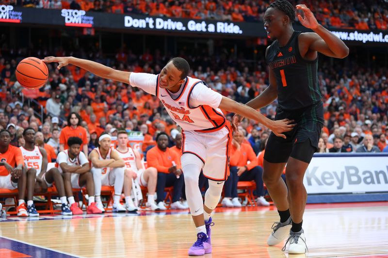 Jan 20, 2024; Syracuse, New York, USA; Syracuse Orange guard Quadir Copeland (24) reaches to save a ball from going out of bounds as Miami (Fl) Hurricanes center Michael Nwoko (1) defends during the second half at the JMA Wireless Dome. Mandatory Credit: Rich Barnes-USA TODAY Sports