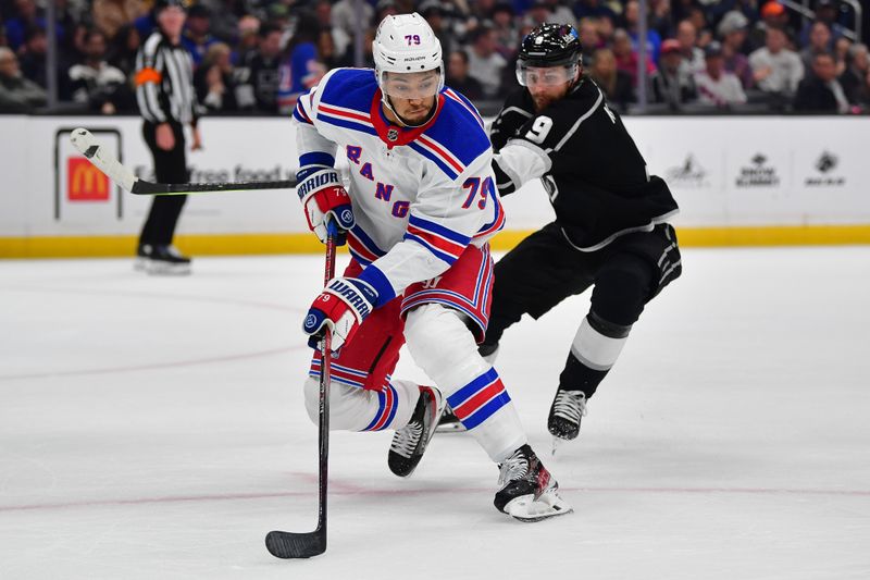 Jan 20, 2024; Los Angeles, California, USA; New York Rangers defenseman K'Andre Miller (79) moves the puck ahead of Los Angeles Kings right wing Adrian Kempe (9) durng the second period at Crypto.com Arena. Mandatory Credit: Gary A. Vasquez-USA TODAY Sports