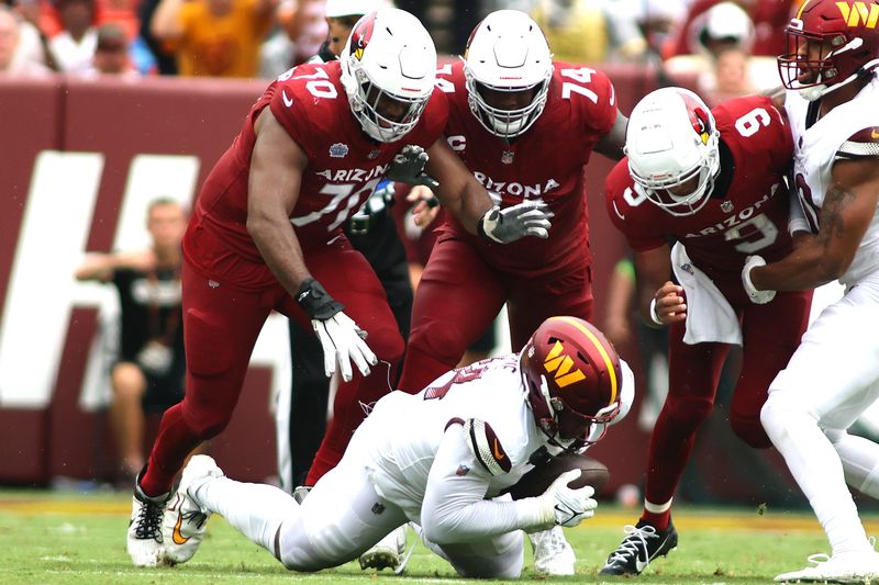 Washington Commanders defensive tackle Daron Payne (94) recovers a fumble during an NFL football game against the Arizona Cardinals, Sunday, September 10, 2023 in Landover, Maryland. (AP Photo/Daniel Kucin Jr.)