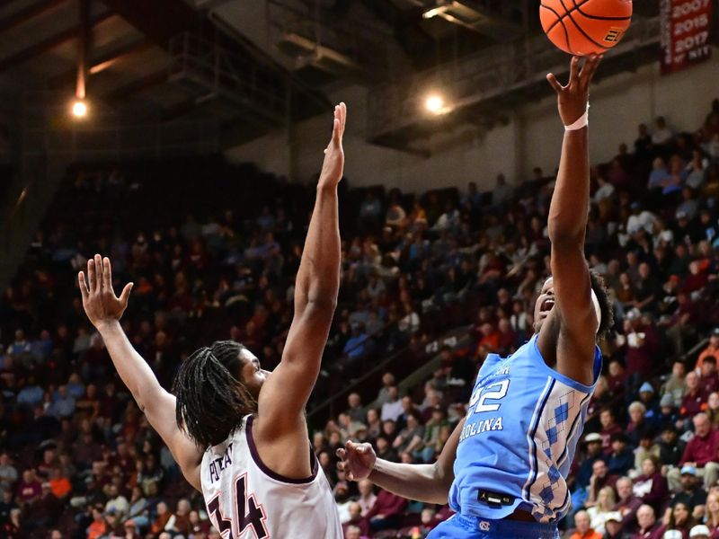 Mar 4, 2025; Blacksburg, Virginia, USA;  North Carolina Tar Heels forward Ven-Allen Lubin (22) shoots a shot as Virginia Tech Hokies forward Mylyjael Poteat (34) defends at Cassell Coliseum. Mandatory Credit: Brian Bishop-Imagn Images