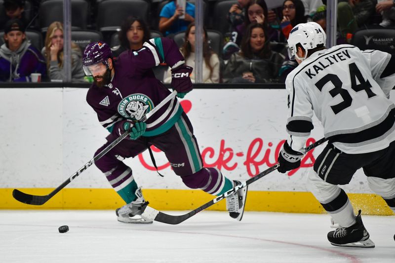 Nov 24, 2023; Anaheim, California, USA; Anaheim Ducks defenseman Radko Gudas (7) moves the puck against Los Angeles Kings right wing Arthur Kaliyev (34) during the third period at Honda Center. Mandatory Credit: Gary A. Vasquez-USA TODAY Sports