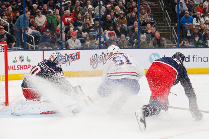 Nov 27, 2024; Columbus, Ohio, USA; Montreal Canadiens left wing Emil Heineman (51) scores a goal over the pad of Columbus Blue Jackets goalie Elvis Merzlikins (90) during the third period at Nationwide Arena. Mandatory Credit: Russell LaBounty-Imagn Images