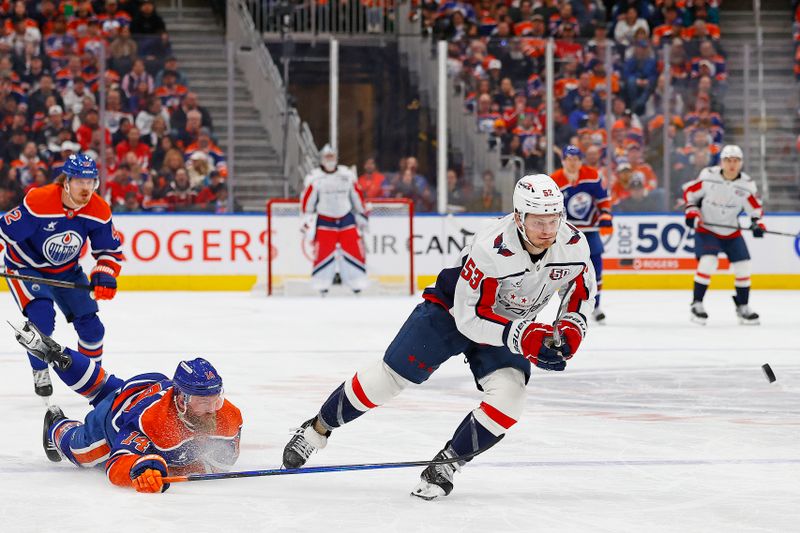 Jan 21, 2025; Edmonton, Alberta, CAN; Edmonton Oilers forward defensemen Mattias Ekholm (14) knocks the puck away from Washington Capitals forward Ethen Frank (53) during the second period at Rogers Place. Mandatory Credit: Perry Nelson-Imagn Images